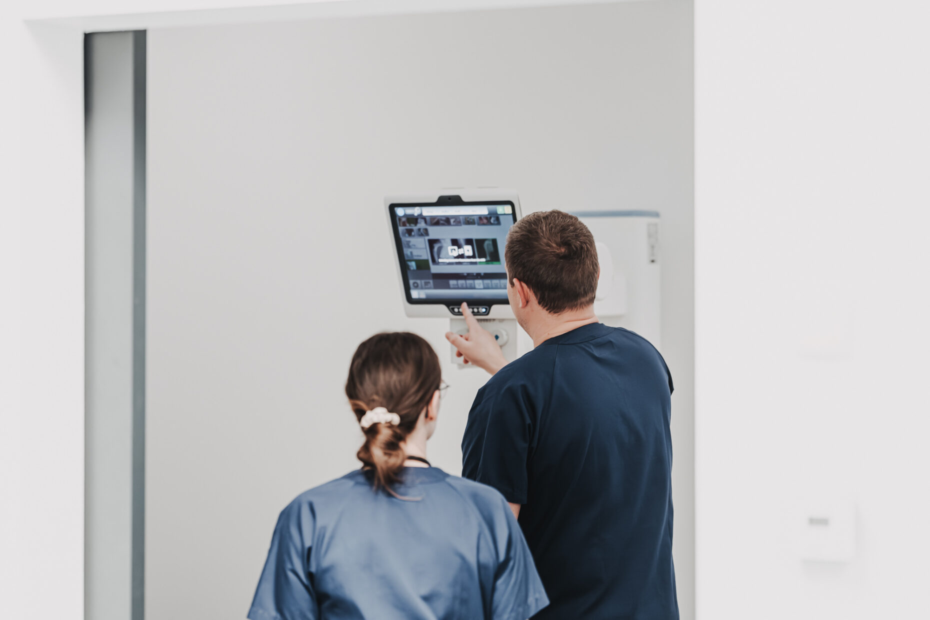 Zwei Ärzt:innen in der Tierklinik Posthausen schauen von hinten auf einen Monitor mit Röntgenbildern.